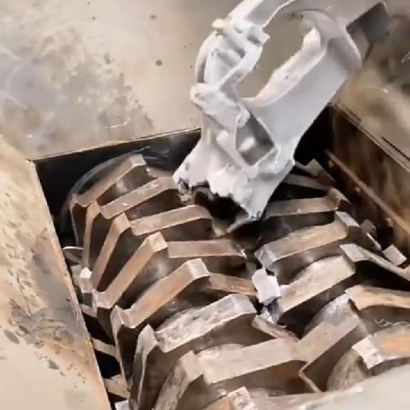 Industrial scrap metal shredder processing engine housings with H13 steel blades